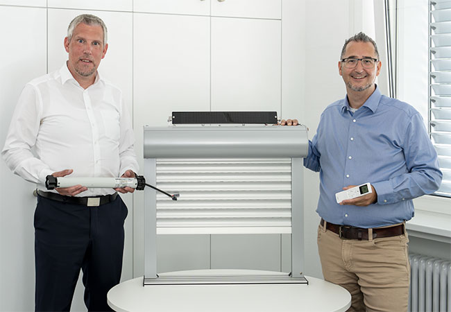 Jörn Wilberg und Frederico Ferreira präsentieren den neuen SE Solar-com Solar-Rolladenmotor
